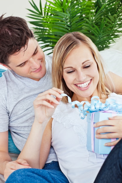 Pareja acostada en el sofá con un regalo