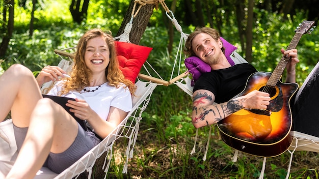 Pareja, acostado, en, hamacas, joven, es, tocar la guitarra