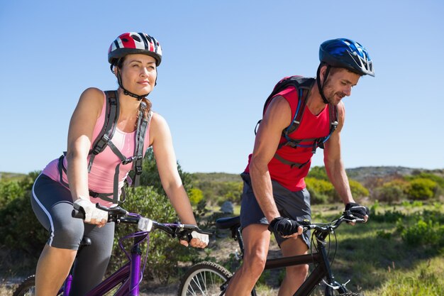 Foto pareja activa ciclismo en el campo