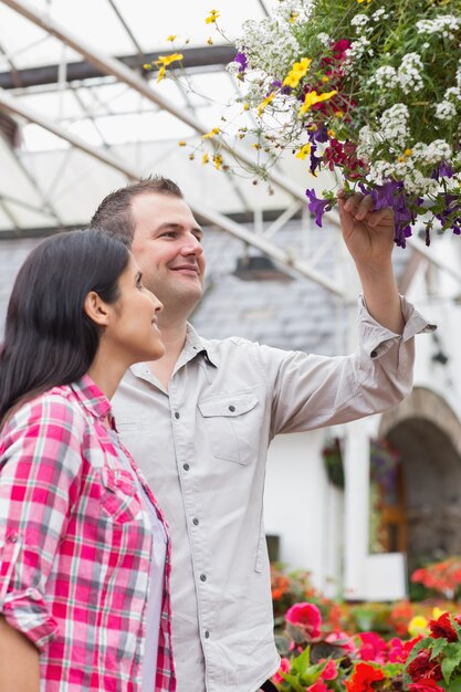 Pareja admirando canasta de flores colgantes