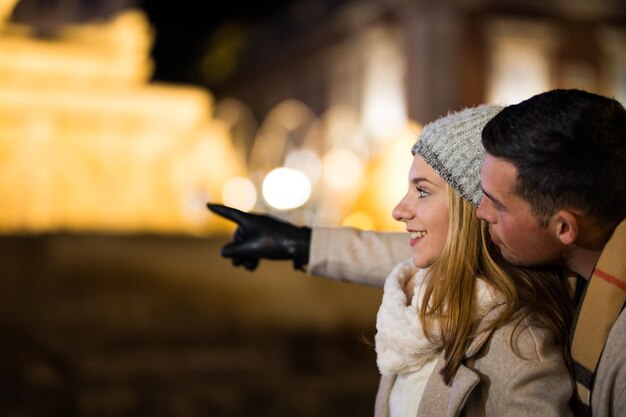 La pareja de adolescentes apuntando con las manos al aire libre por la noche