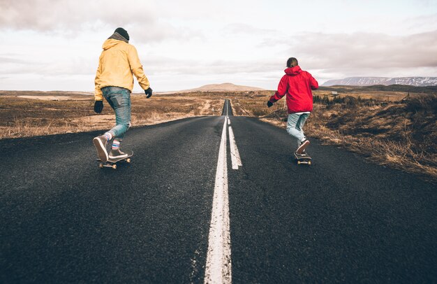 Pareja de adolescentes divirtiéndose patinando y haciendo descenso