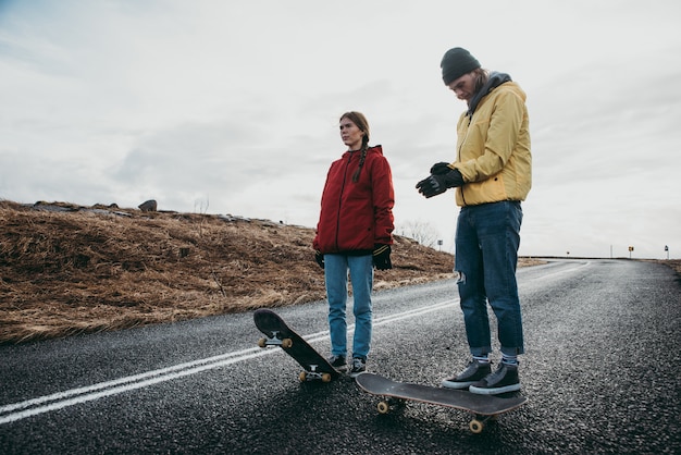 Pareja de adolescentes divirtiéndose patinando y haciendo descenso