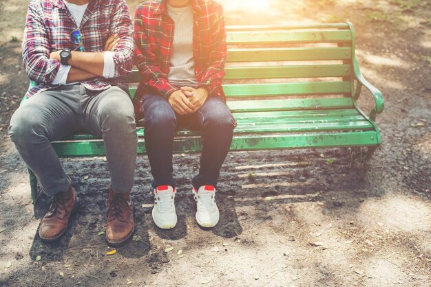 Una pareja de adolescentes enamorados sentados juntos en el banco del parque.