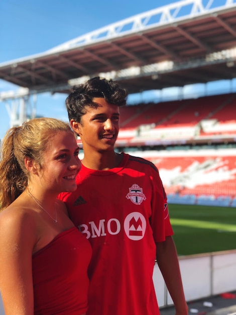 Foto una pareja de adolescentes de pie en el estadio