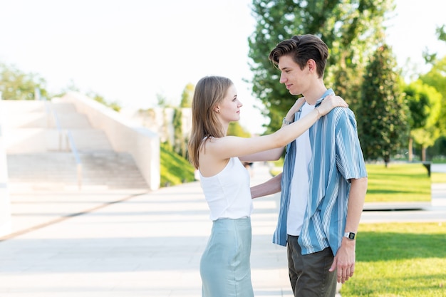 Pareja de adolescentes tomados de la mano y abrazándose en el parque El primer amor