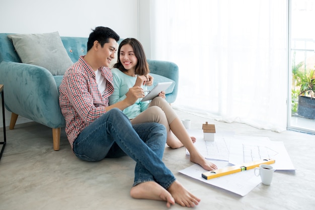 Pareja adulta asiática joven atractiva que planea el nuevo diseño de la casa.