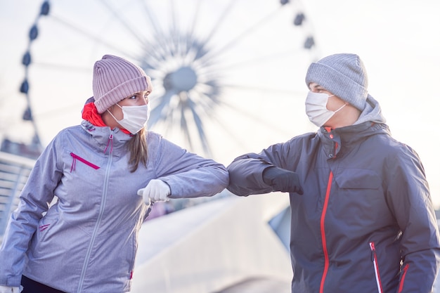 Pareja adulta trotar en la ciudad con máscaras durante la pandemia de encierro