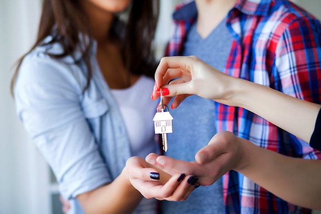 Foto pareja de adultos jóvenes dentro de la habitación con cajas sosteniendo la nueva casa keys banner.