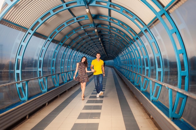 Pareja de adultos jóvenes disfrutando de su amor y posando en un túnel azul futurista