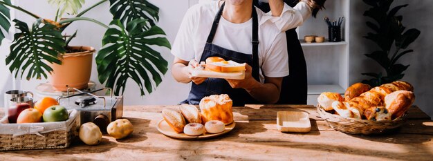 Una pareja de adultos jóvenes felices haciendo el desayuno y bebiendo café juntos en la acogedora cocina de casa por la mañana en casa preparando comidas y sonriendo estilo de vida ocio y concepto de amor
