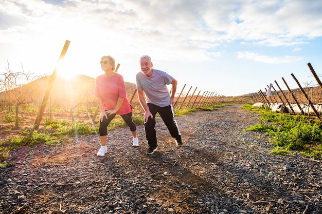 Pareja de adultos mayores haciendo actividad deportiva por la mañana para mantenerse saludables y vivir juntos durante mucho tiempo - fitness y estiramiento para la sociedad de ancianos - personas que realizan actividades de fitness al aire libre concepto