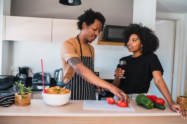 Pareja afro cocinando juntos en la cocina.