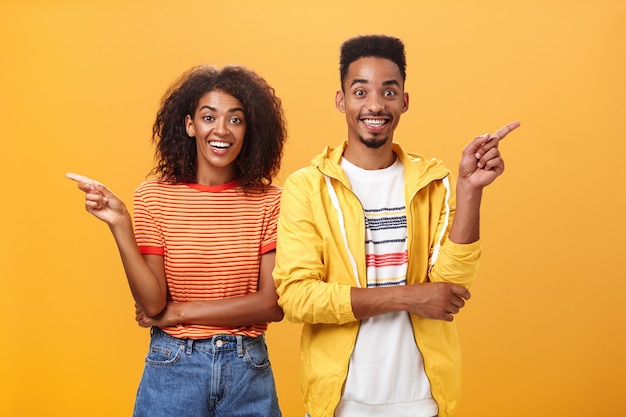 Pareja afroamericana apuntando a ambos lados.