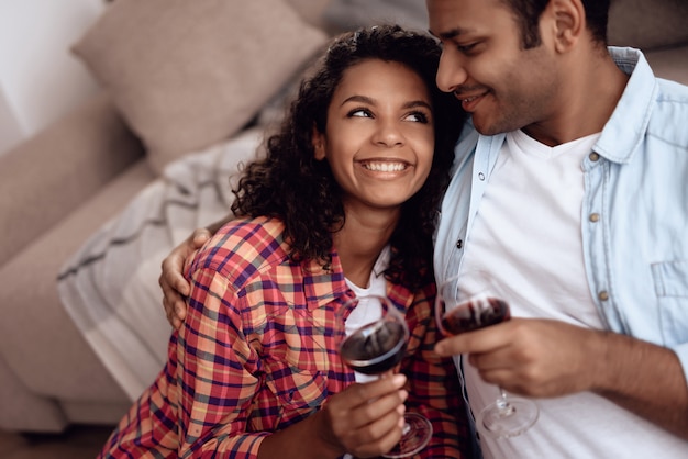 Pareja afroamericana bebe vino en cita romántica