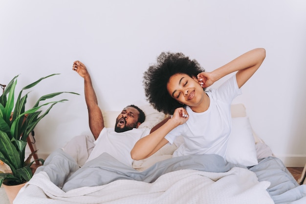 Pareja afroamericana en la cama Real hermosa y alegre pareja de amantes en casa