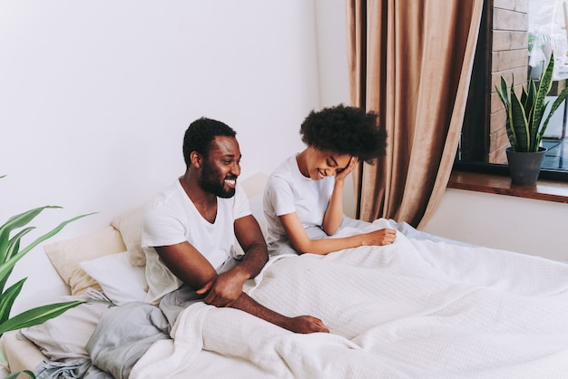 Pareja afroamericana en la cama Real hermosa y alegre pareja de amantes en casa
