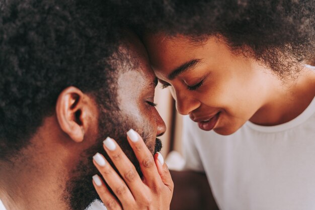 Pareja afroamericana en la cama Real hermosa y alegre pareja de amantes en casa