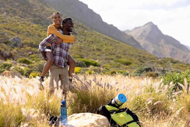 Foto una pareja afroamericana descansando y abrazándose en el campo montañoso. estilo de vida saludable, ejercicio en la naturaleza.