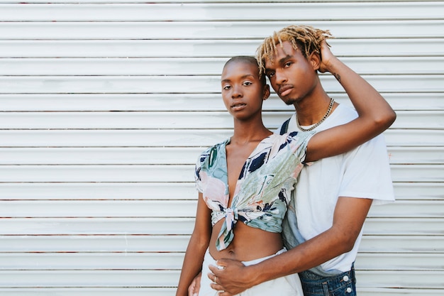 Foto pareja afroamericana posando junto a una pared