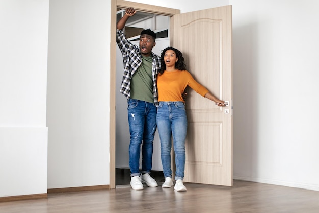 Foto pareja afroamericana sorprendida de pie en puertas abiertas