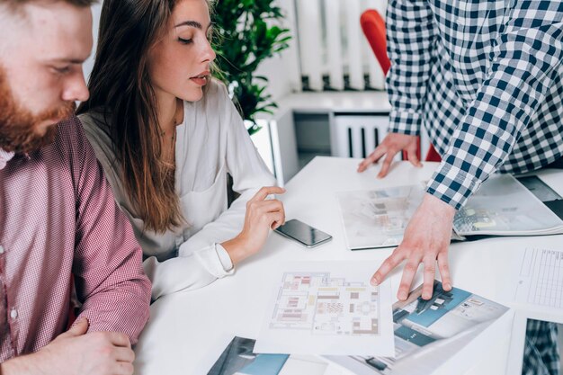 Foto una pareja en una agencia inmobiliaria hablando con un agente inmobiliario