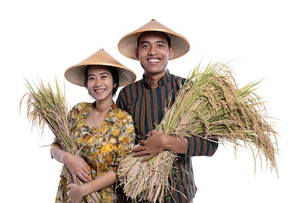 Pareja de agricultores asiáticos con granos de arroz