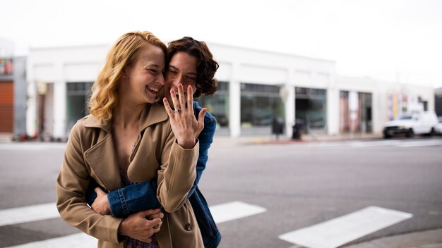 Foto pareja al aire libre en la ciudad después de propuesta con anillo de compromiso