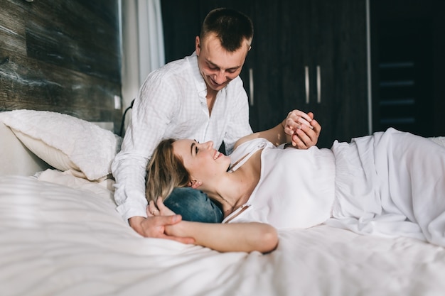 Pareja alegre en la cama