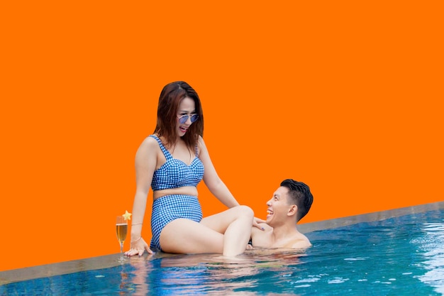 Pareja alegre con gafas de sol en una piscina