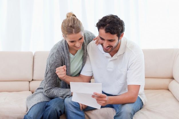 Pareja alegre leyendo una carta