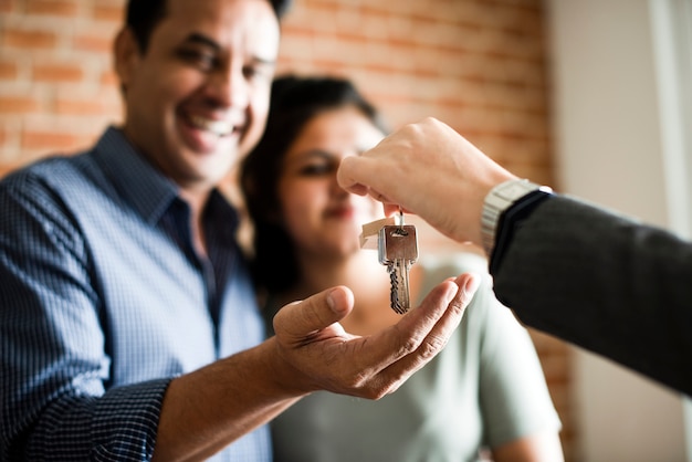 Pareja alegre con las llaves de su nuevo hogar.