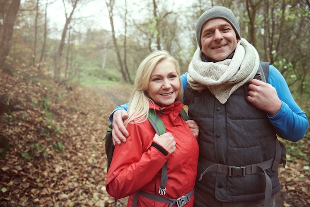 Pareja alegre senderismo en el bosque