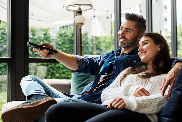 Pareja alegre viendo la televisión juntos