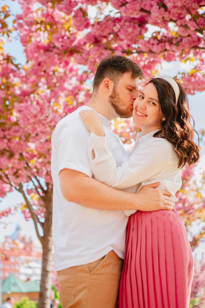 Una pareja de amantes bajo un árbol de sakura en flor.