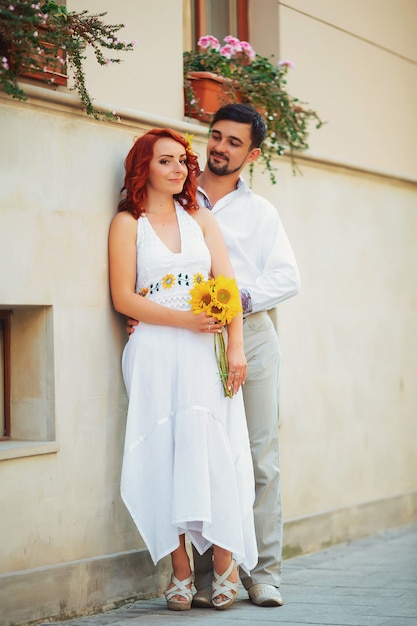 Una pareja de amantes de la gente en la ciudad a pie. La historia de amor de dos jóvenes. Hombre y mujer abrazados. Caminando por la ciudad día de verano. Sentimientos de amor entre dos personas. Historia de amor.