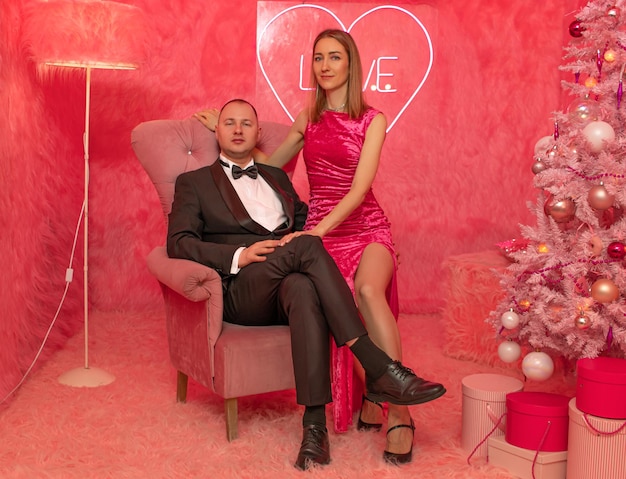 La pareja de amantes en el primer plano de fondo de piel rosa con decoraciones festivas