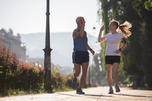 la pareja de amigos trotando felicita y feliz de terminar su entrenamiento matutino