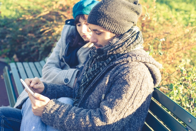 pareja en el amor usando tableta en el parque