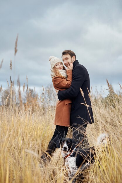 Pareja amorosa abrazando en campo, paisaje de otoño