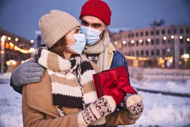 Pareja amorosa caminando afuera en invierno durante la pandemia