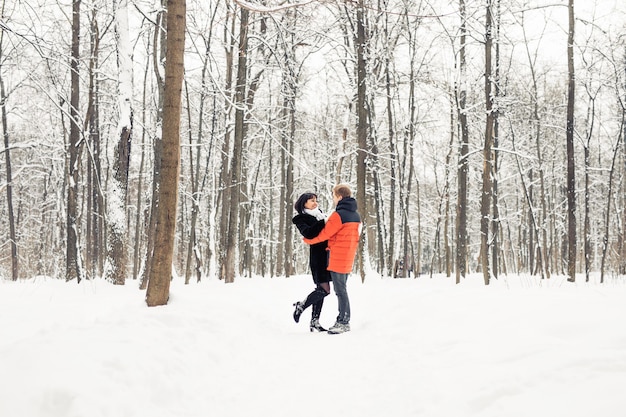 Una pareja amorosa caminando en Winter Park. Está nevando, invierno.