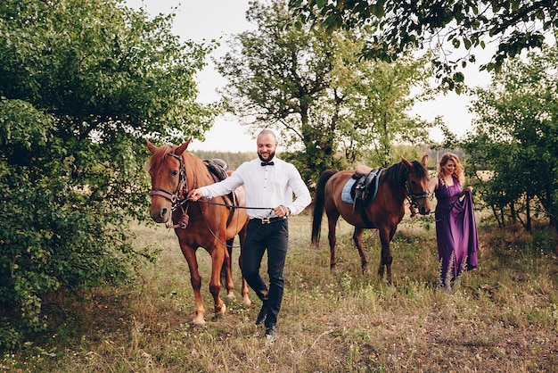 Una pareja amorosa en una cita. Cabalgatas. Vestido morado.