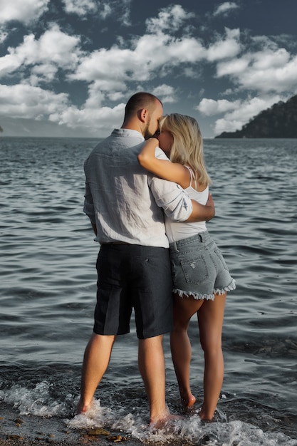 Pareja amorosa disfrutando de la luna de miel en el hotel de playa de territorio con vista de lujo caminando muestra emoción en el fondo del mar. Amantes felices en la diversión del viaje romántico en las vacaciones de verano. Concepto de romance y relajación