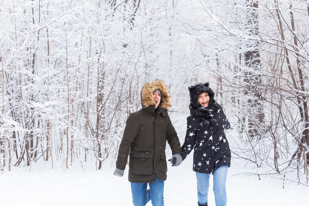 Pareja amorosa divirtiéndose al aire libre en el parque de nieve