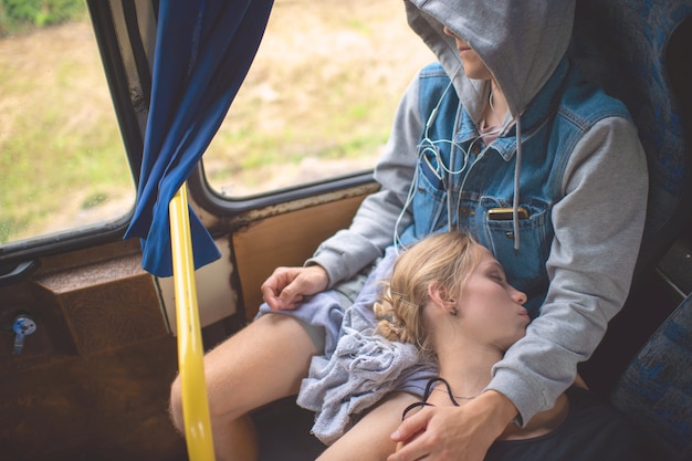 Pareja amorosa durmiendo y abrazándose en autobús