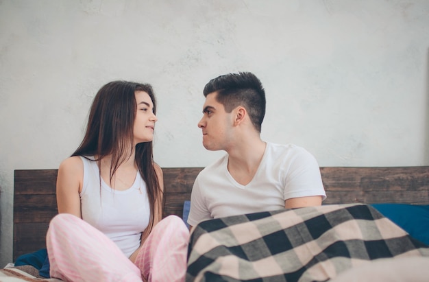 Una pareja amorosa está acostada en la cama. Dormitorio luminoso y acogedor. Amor y consuelo familiar