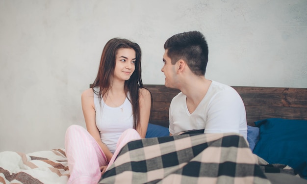 Una pareja amorosa está acostada en la cama. Dormitorio luminoso y acogedor. Amor y consuelo familiar