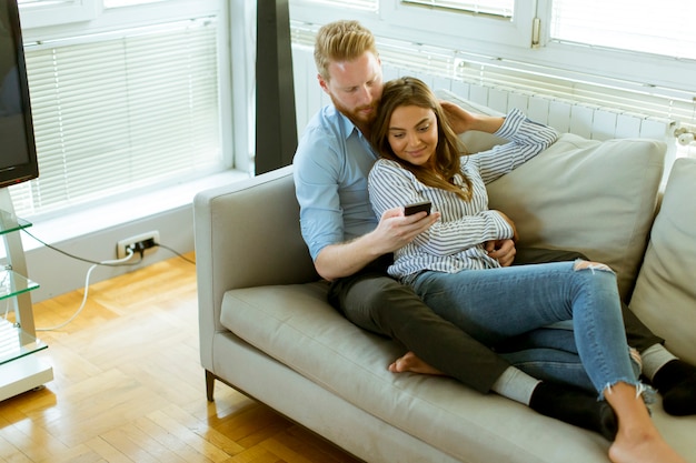 Pareja amorosa en la habitación con teléfono móvil.