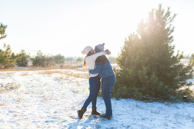 Pareja amorosa jugar bolas de nieve en invierno en el bosque.